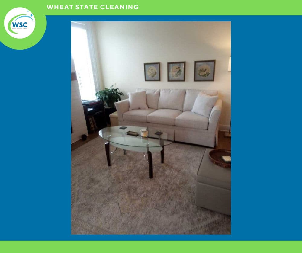 Living room with a light sofa, glass coffee table, and decorative art on the walls.