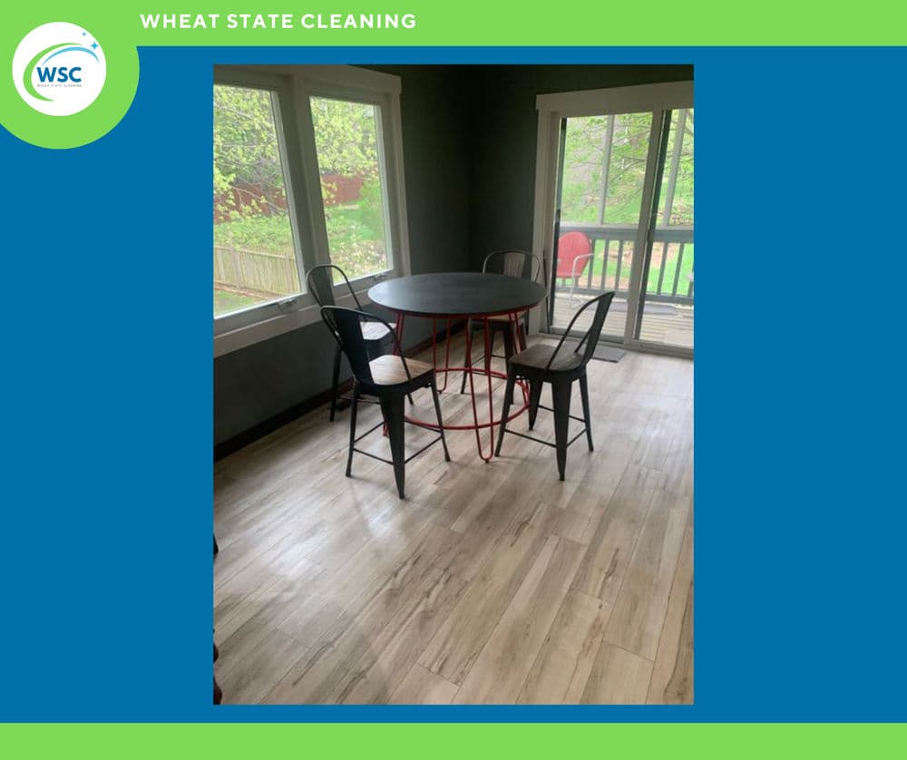 Modern dining area featuring a round table with metal chairs and large windows.